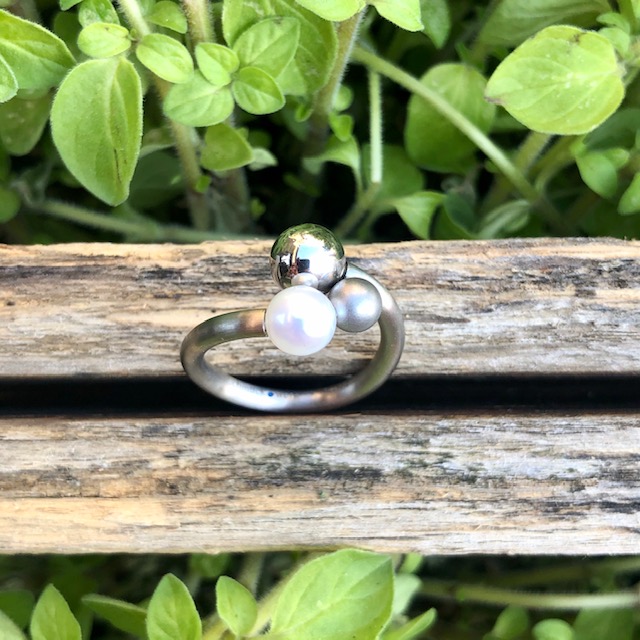 Schmuckwerk Perlenrausch Drilling Ring aus Edelstahl, Ein jugendliches Designstück, welches nicht durch sein Volumen besticht, sondern durch die verschiedenen Größen der 3 kugeligen Elemente - der Perle, einer mattierten und einer polierten Stahlkugel. Aller guten Dinge sind drei.