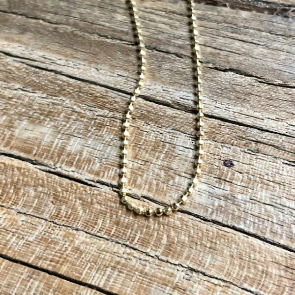 Zarte Goldkette Gelbgold aus kleine facettierten Kügelchen 14kt auf Holz fotografiert